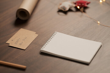 White empty paper notepad with christmas decorations on walnut table