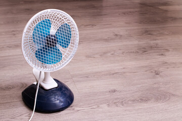 Small fan on the wooden floor closeup