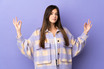 Teenager Brazilian girl over isolated purple background in zen pose