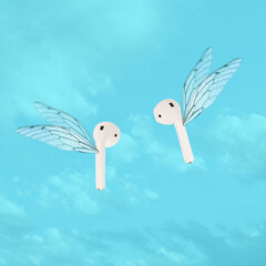 Modern wireless ear phones flying with wings. Sound listening concept photo. In ear headphones....