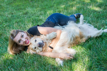 Young blonde with her retriever dog outdoors.
