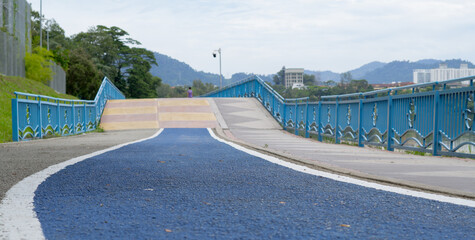 Urban lifestyle cycling road in the public park nearby lake. Greenery scene and clear cloud in the sky in background. 