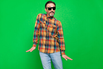 Portrait of attractive cheerful man fooling dancing having fun moving rest isolated over bright green color background