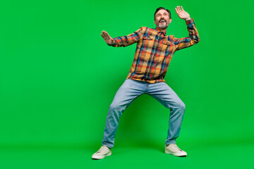 Full length body size view of attractive cheerful man dancing having fun chill out clubbing isolated over bright green color background