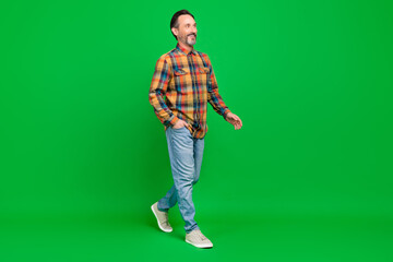 Fototapeta premium Full length body size view of attractive cheerful man going wearing cozy clothes isolated over bright green color background