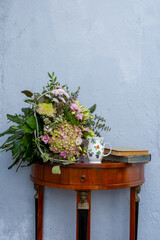 antique sideboard with flowers,  porcelain cup and books