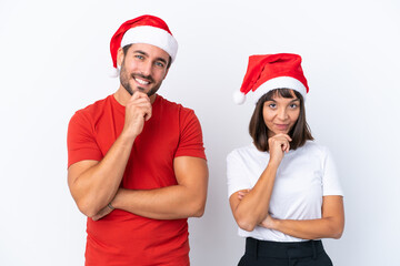 Young couple with christmas hat isolated on white background smiling and looking to the front with confident face