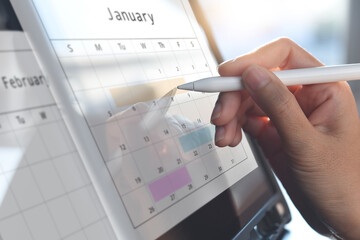 Calendar planner organization management remind concept. Business woman using digital tablet pc with calendar and planner for events planning on January 2022