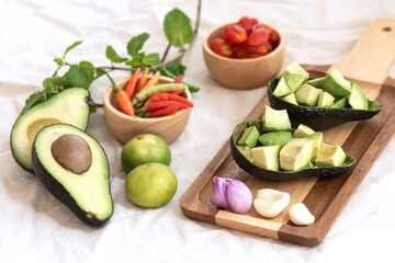 Avocado,tomato with fresh herbs in thai style salad in shell put on wooden tray.