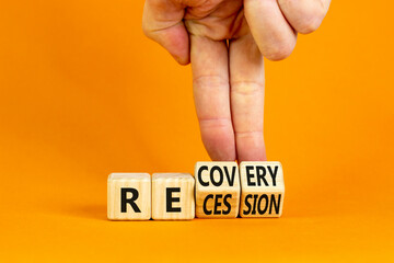 Recovery and recession symbol. Businessman hand turns cubes and changes the word 'recession' to 'recovery'. Beautiful orange background. Business and recovery - recession concept. Copy space.