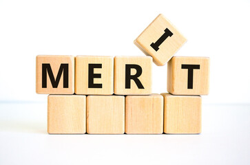 Merit symbol. The concept word 'merit' on wooden cubes on a beautiful white table. White background. Business and merit concept.