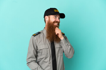Redhead security man isolated on white background looking to the side