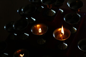 Buddhist Old Altar Candles at Religious Butter Lamp Festival in Temple Monastery. Beautiful Tranquil Scenic View of Oil Lamps and Swaying Flame for Praying 