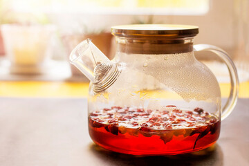 Hot rosehip drink in a glass teapot