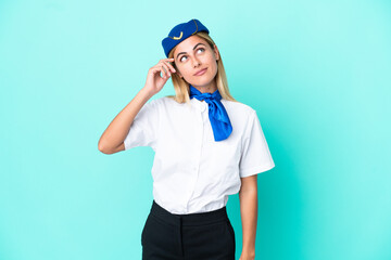 Airplane stewardess Uruguayan woman isolated on blue background having doubts and with confuse face expression