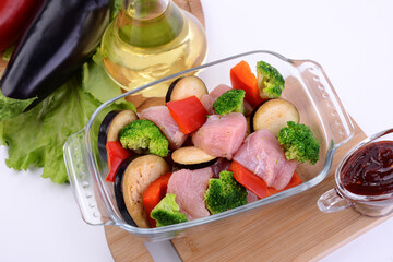 raw chicken with vegetables in a glass dish 