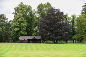 Obraz premium Cricket pitch and wooden pavillion building