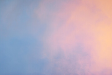 Soft pink purple cloud illuminated by golden light over blue sky background in twilight time. Empty natural sky with pastel tone colors for background or wallpaper.
