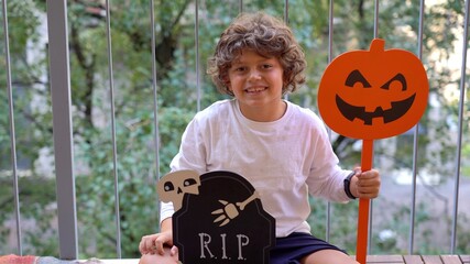 7 year old caucasian child awaits the arrival of Halloween day at home on the balcony during...