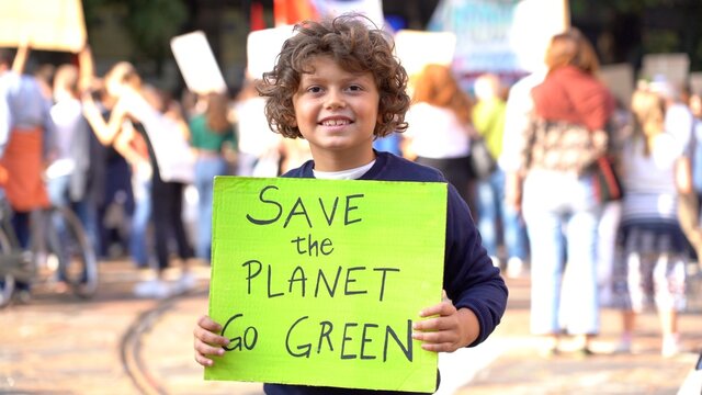 Italia, Milano , Activist boy Child 7 years old with sign Save the Planet , go green - Friday for Future Youth 4 Climate - student demonstration against climate change and global warming 