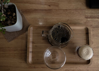 The americano in jar and small cup and empty cup for customer in coffee shop on wooden tray