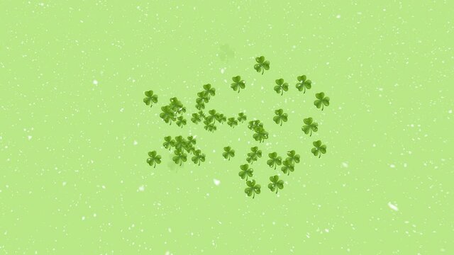 Animation of clover leaves and snow falling over green background