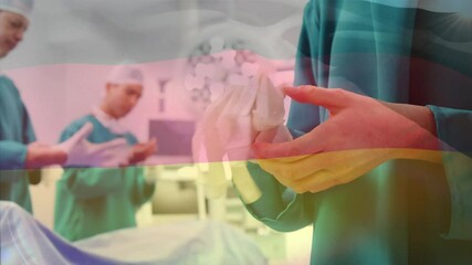 Animation of flag of germany waving over surgeons in operating theatre - Powered by Adobe
