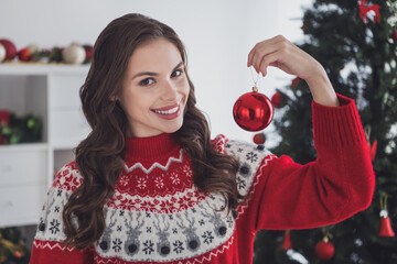 Portrait of attractive cheerful wavy-haired girl holding ball tree toy domestic custom staying at workplace home indoors