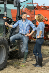 Farmer couple next to their tractor in the filed