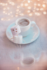 A cup of coffee with Christmas lights, top view.