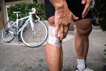Closeup of cyclist bandaging wounds following road rash