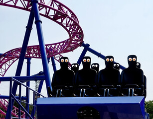 Empty roller coaster seats with goofy googly eyes. Fun. Humor. 