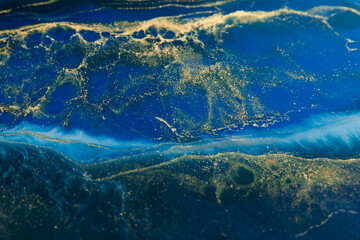 Resin art with bright blue and golden colors. Epoxy effect
