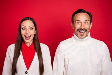 Photo of amazed positive mature man and woman couple christmas good mood xmas spirit isolated on red color background