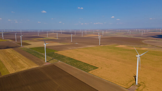 Aerial photography of a wind turbine from a wind farm in country side. Photography was taken from a drone at lower altitude in mid day. Wind generator farm aerial photo