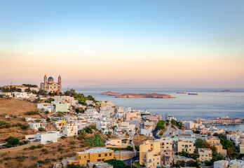 Scenic sunset in Ermoupolis, the capital of Cyclades, Greece, with the Church of the Resurrection of Our Savior on the left and the Aegean Sea in the background. Photo taken from Ano Syros.
