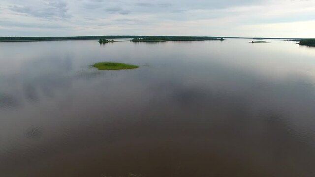 Takeoff over Lake.	Filming from a drone taking off over the lake. The lake is located among forests and swamps. On the island's lake.