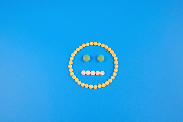 emoticon laid out from yellow, white and green pills