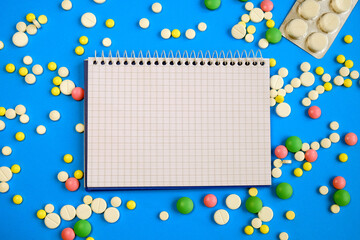 Plaid notebook lies horizontally on a blue background among the tablets