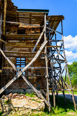 Wooden scaffolding near the old building. Ancient building restoration