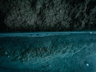 Swimming point of view inside ocean cave, flat surface