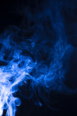 The movement of blue smoke faces a fierce fierce black background on abstract things on a black background.