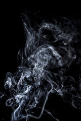 The smooth movement of white smoke on a black background, abstract things on a black background.
