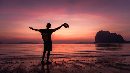 Fototapeta premium Silhouette happy man traveler arm up joy fun on summer vacation at sunset Pak Meng beach, Leisure outdoor lifestyle tourist travel Trang Thailand, Tourism beautiful destination place Asia holiday trip