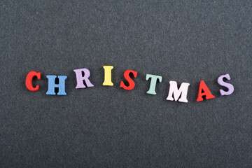 CHRISTMAS word on black board background composed from colorful abc alphabet block wooden letters, copy space for ad text. Learning english concept.