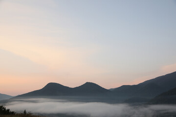 Picturesque view of mountains covered with fog in morning