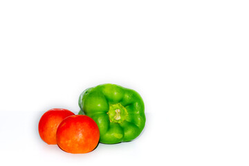Two tomatoes and a capsicum green chili isolated on white background