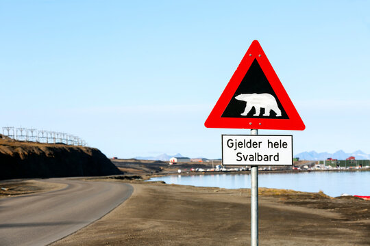 Polar bear warning sign in Svalbard, located at the end of Longyearbyen town. Translation "Gjelder hele Svalbard" - valid to whole of Svalbard. Scenic view of arctic wild nature.
