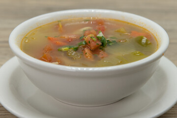 Soothing warm bowl of chicken vegetable soup on a saucer for a hearty meal
