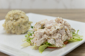Loaded turkey salad sandwich served without the bread and a side order scoop of potato salad